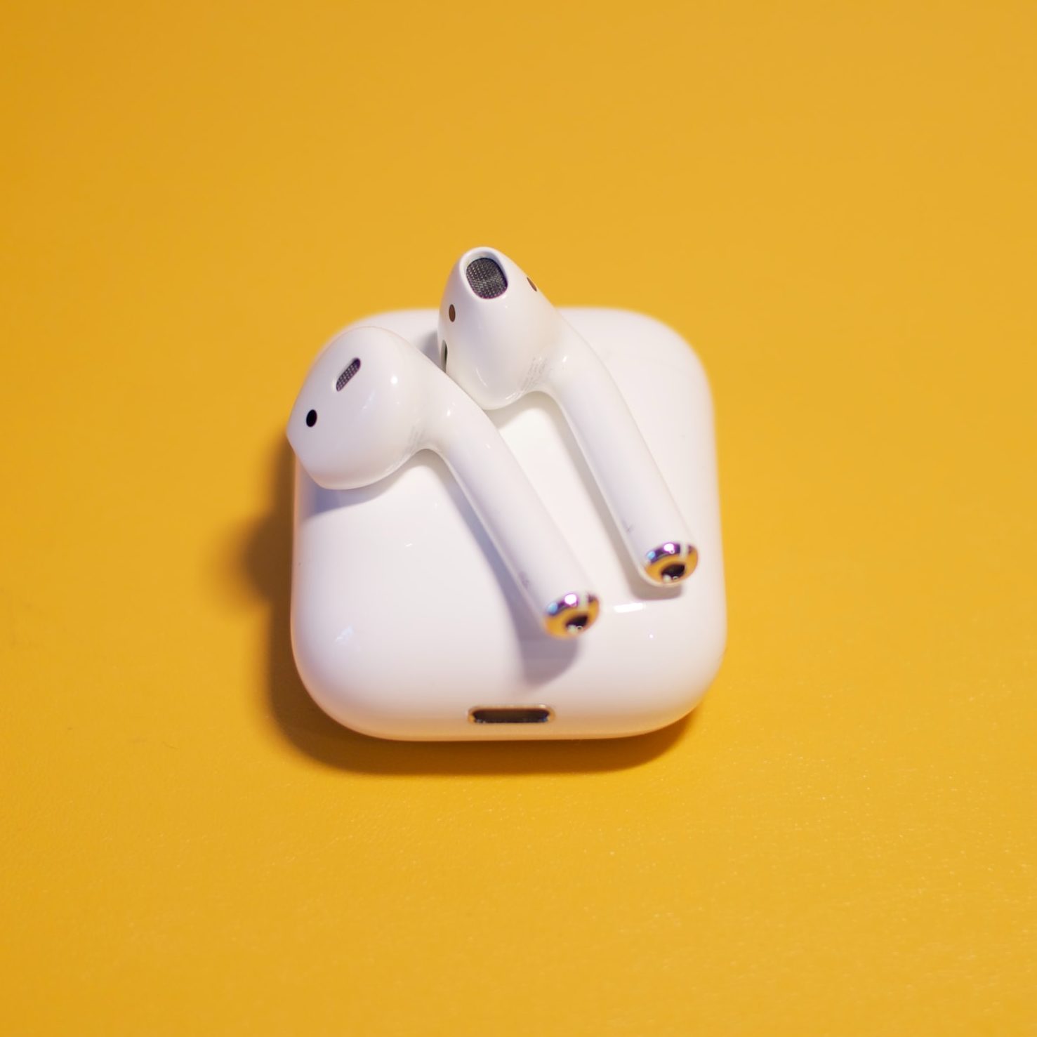 AirPods 2 on case with yellow background