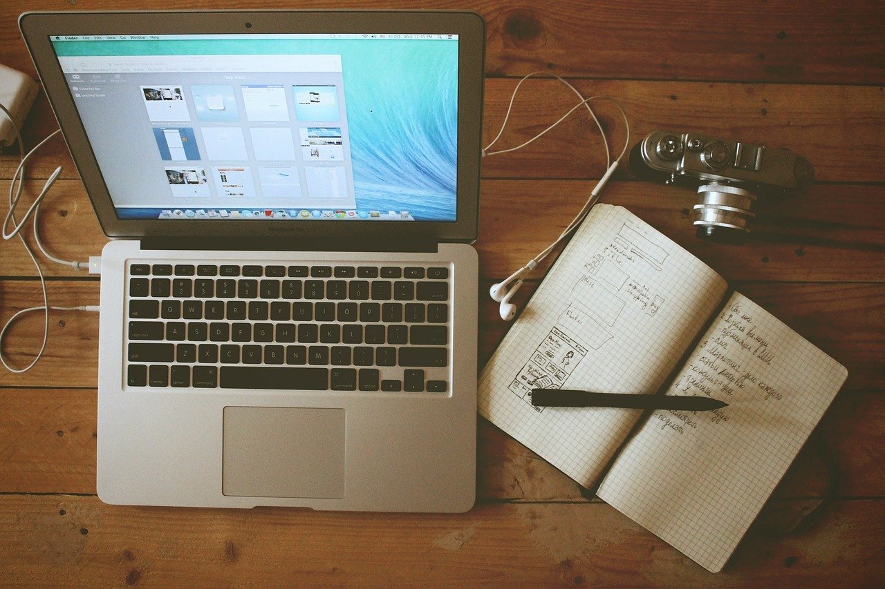 MacBook on a table with handwritten notes