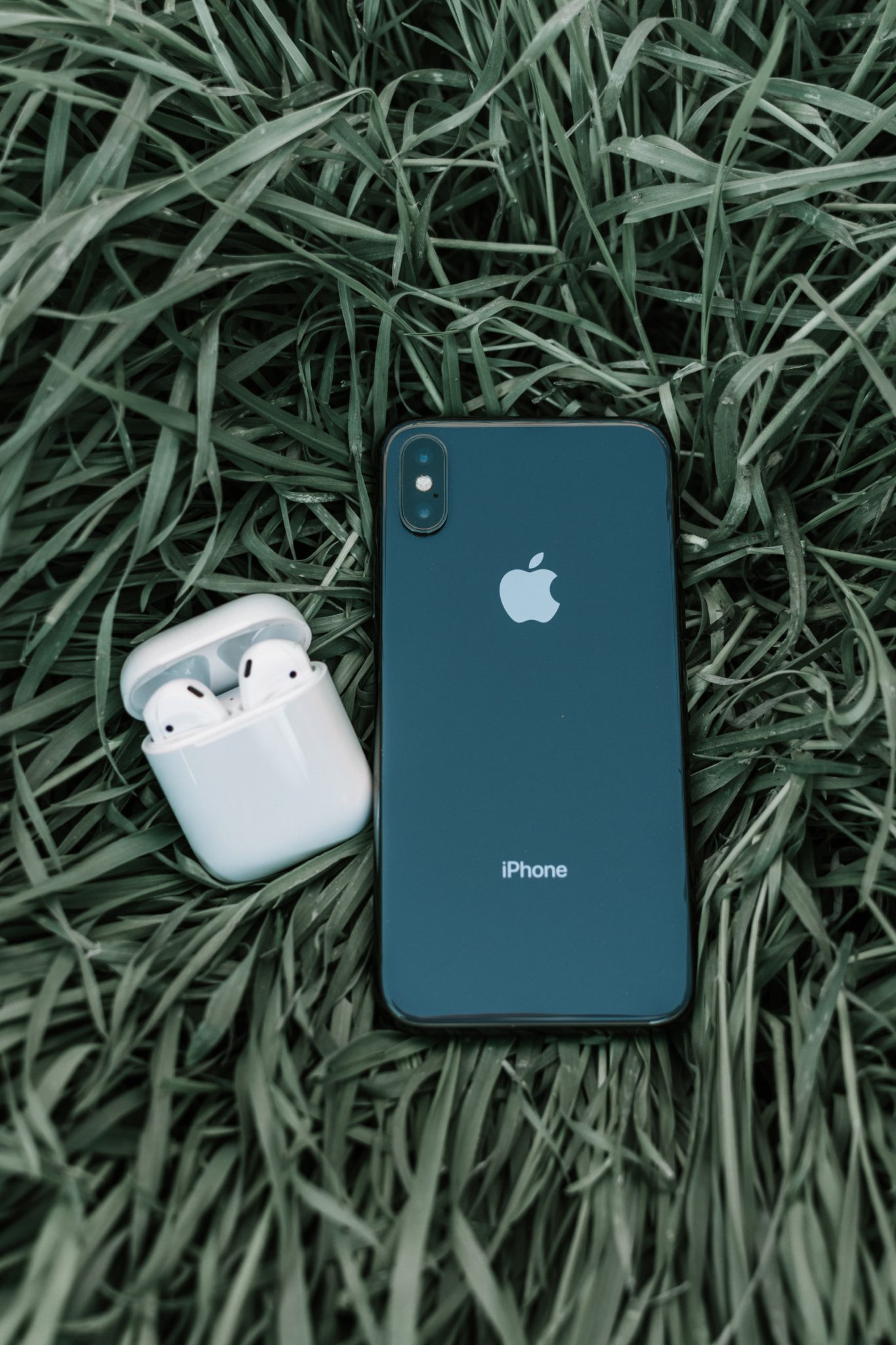 AirPods y iPhone sobre la hierba representando la economía circular y verde