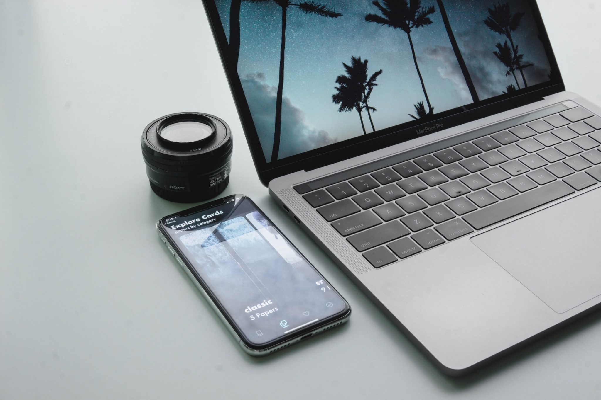 MacBook, smartphone y objetivo de cámara