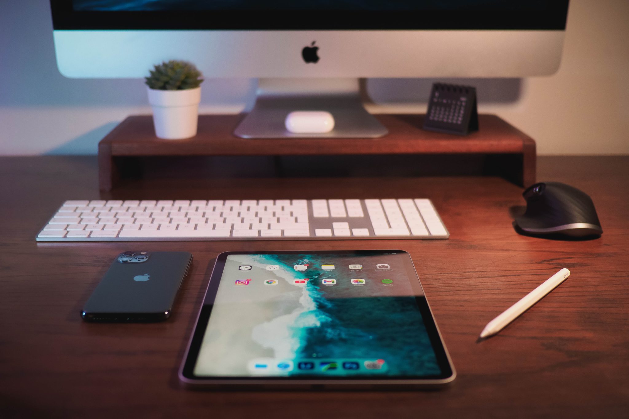Apple devices on a wooden desk